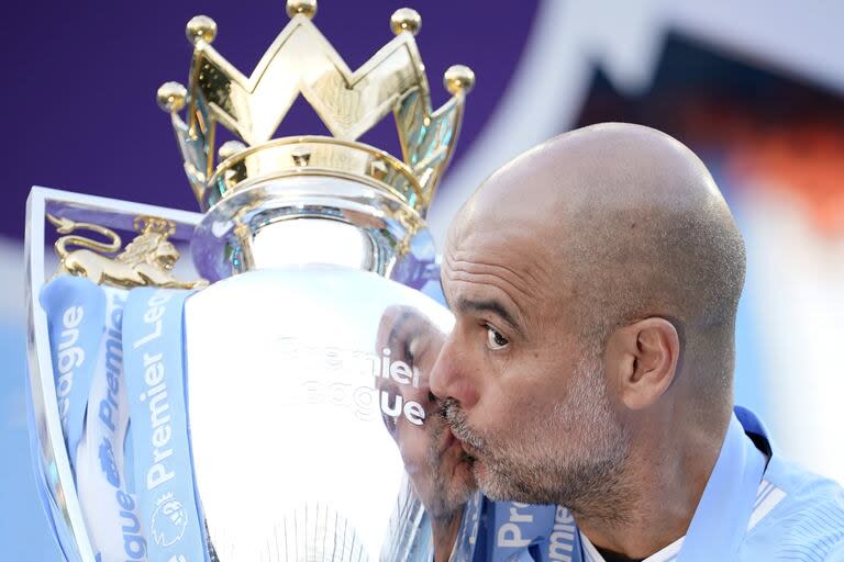 Guardiola besa el trofeo al campeón de la Premier League; su Manchester City se coronó como el primer tetracampeón de la historia