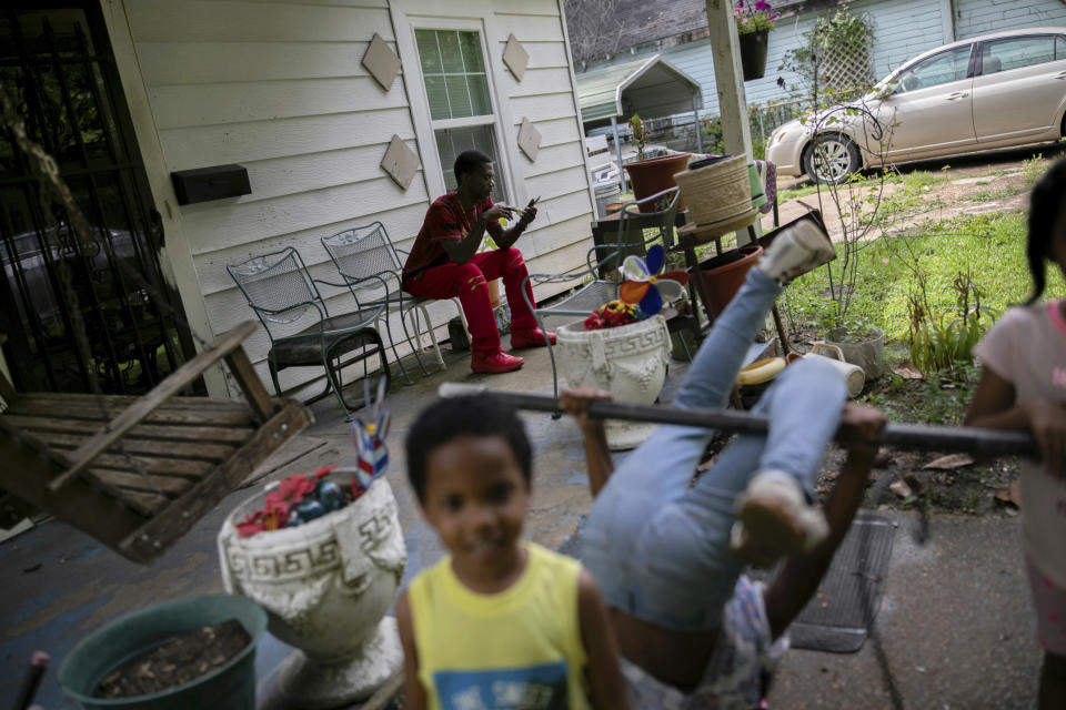 Joshua K. Love relaxes with his nieces and nephews on the front porch of his grandmother's home in Greenwood, Miss., Saturday, June 8, 2019. (AP Photo/Wong Maye-E)