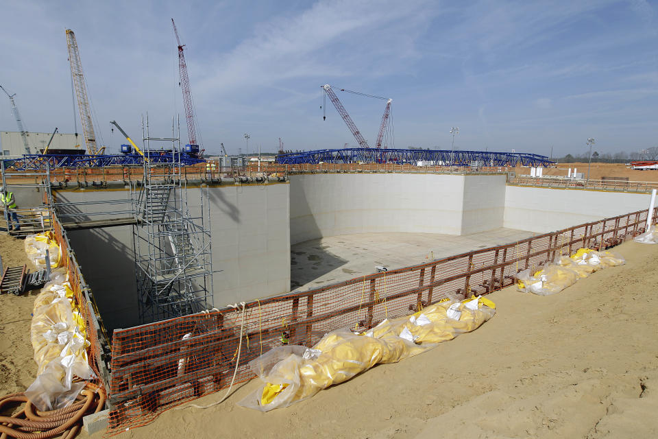 FILE- In this Feb. 15, 2012 file pool photo, the Unit 3 nuclear island where a new nuclear reactor will sit is seen before a visit by U.S. Secretary of Energy Secretary Steven Chu at the Vogtle nuclear power plant in Waynesboro, Ga. Vogtle initially estimated to cost $14 billion, has run into over $800 million in extra charges related to licensing delays. A state monitor has said bluntly that co-owner, Southern Co. can’t stick to its budget. The plant, whose first reactor was supposed to be operational by April 2016, is now delayed seven months.(AP Photo/David Goldman, Pool, File)
