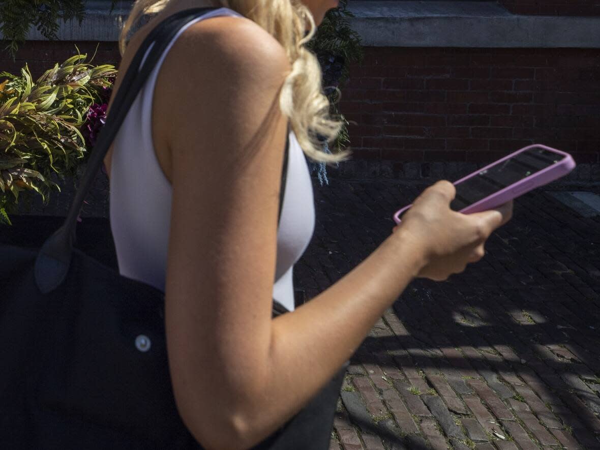 A woman is pictured in Vancouver on July 27, 2022. A class-action lawsuit based in B.C. accuses the company behind the Flo Health period and fertility-tracking app of sharing users' personal information with third parties like Facebook without their knowledge. (Ben Nelms/CBC - image credit)
