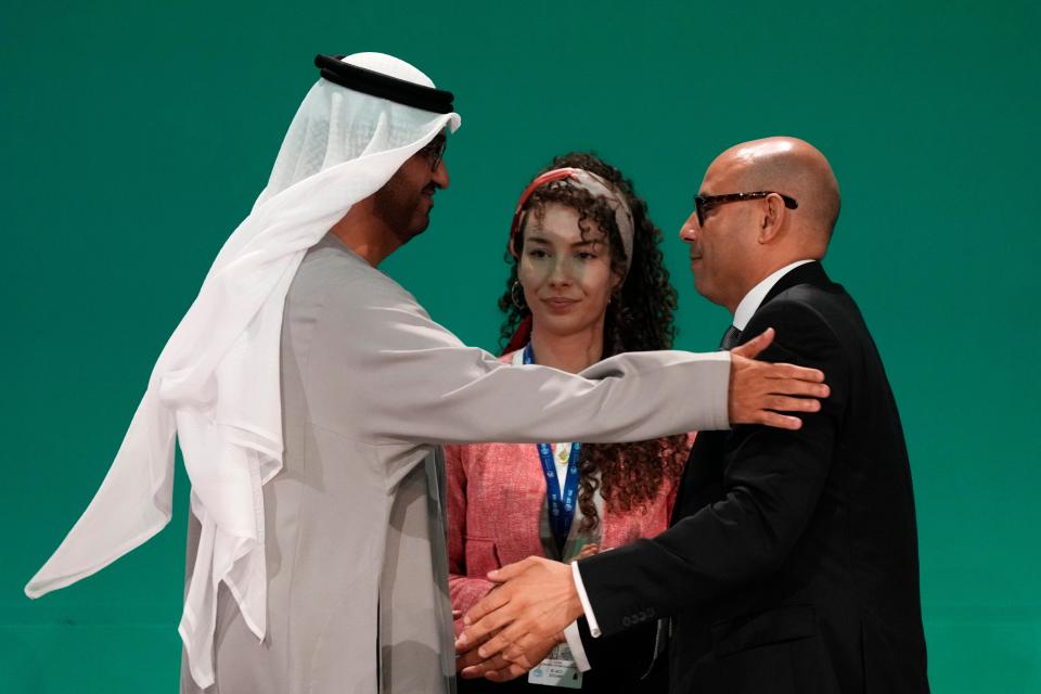 United Nations Climate Chief Simon Stiell, right, and Cop28 president Sultan al-Jaber embrace at the Cop28 (AP)