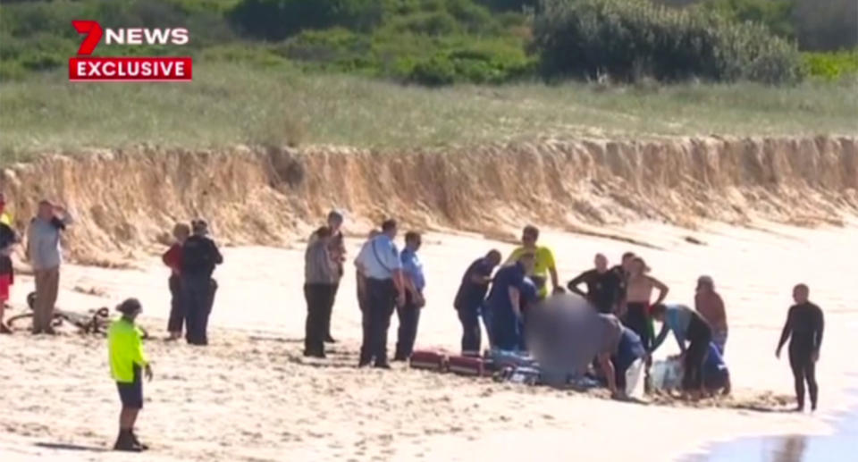 Paramedics tend to the 59-year-old on the beach after he was attacked.