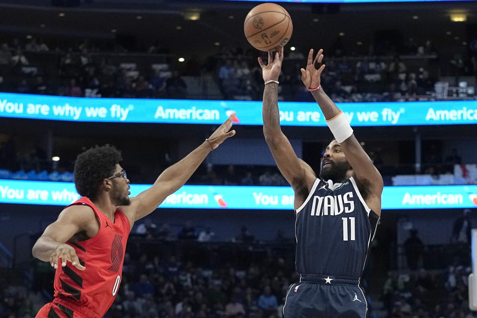 Dallas Mavericks guard Kyrie Irving (11) shoots against Portland Trail Blazers guard Scoot Henderson (00) during the first half of an NBA basketball game in Dallas, Wednesday, Jan. 3, 2024. (AP Photo/LM Otero)