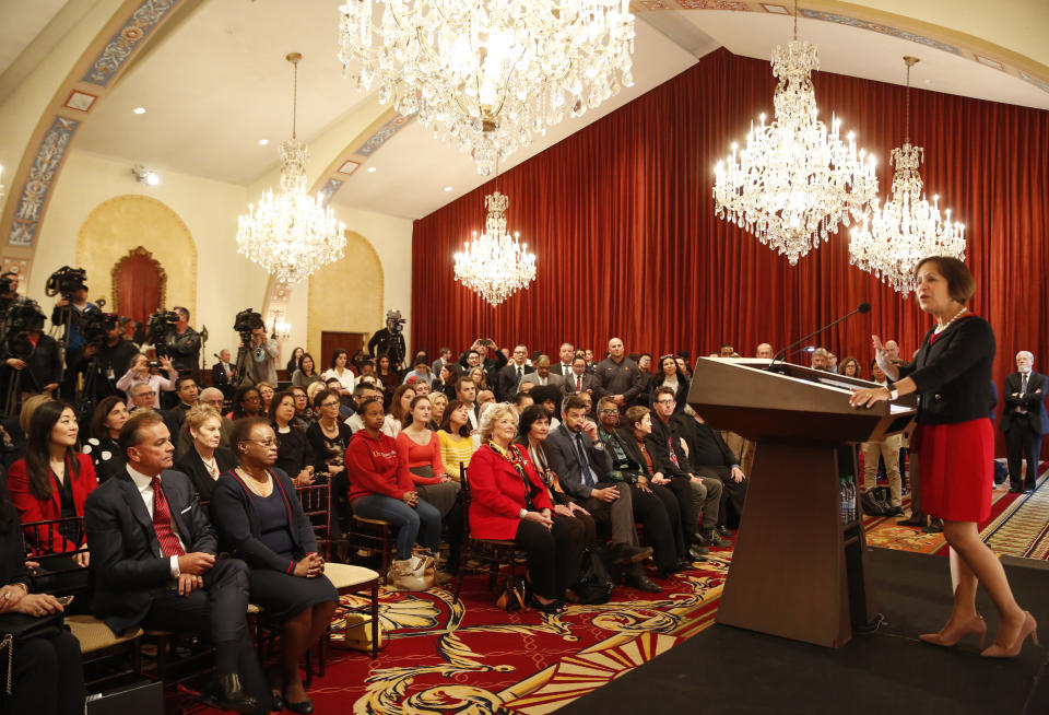 Carol Folt, right, standing at podium takes questions after being named as University of Southern California's 12th president, Wednesday, March 20, 2019, at Town & Gown of USC building in Los Angeles. The announcement comes a week after news broke of a massive college bribery scam involving USC and other universities across the country. Folt most recently was formerly the chancellor of the University of North Carolina at Chapel Hill (UNC). She will take office as USC's new president on July 1. (AP Photo/Damian Dovarganes)