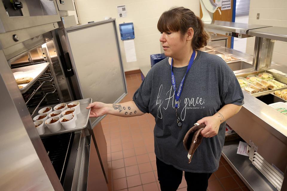Head cook Jess Scheufler puts away prepared cups of food during lunch at Tuslaw High School.