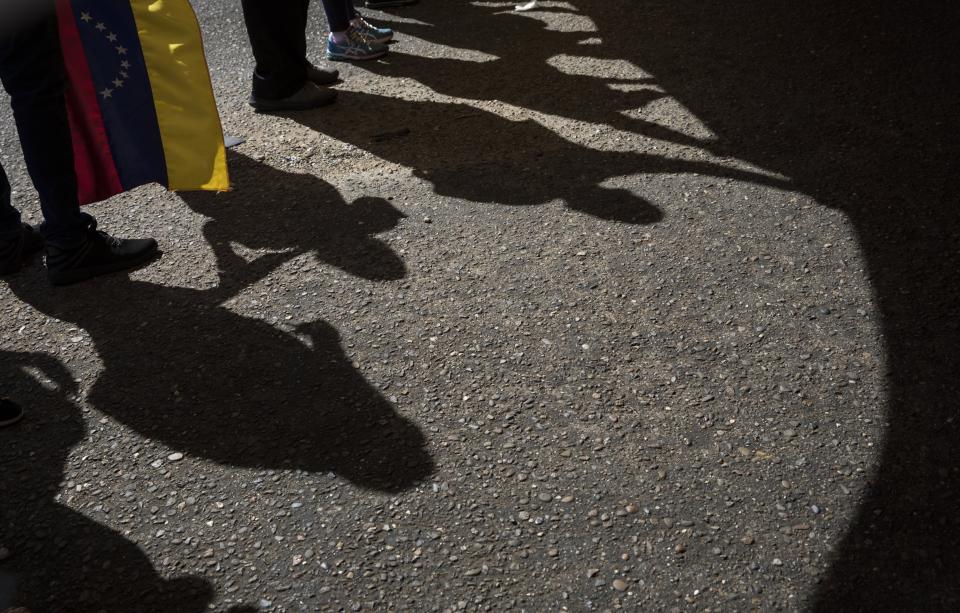 In this Nov. 16, 2019 photo, shadows of anti-government protestors are cast on the asphalt during a demonstration in Maracaibo, Venezuela. Opposition leader Juan Guaido, who seeks to oust President Nicolas Maduro, has urged Venezuelans to take to the streets, trying to reignite a movement started early this year. However, few in Maracaibo have responded, despite it being a city hard hit by crisis. (AP Photo/Rodrigo Abd)