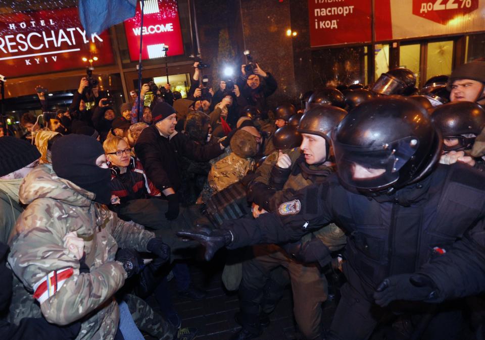 Far-right activists clash with riot police in front of an Alfa-Bank in central Kiev, Ukraine, Tuesday, March 14, 2017. Activists and supporters of Ukrainian nationalist groups are demanding the closure of all banks associated with Russia in Ukraine. (AP Photo/Sergei Chuzavkov)