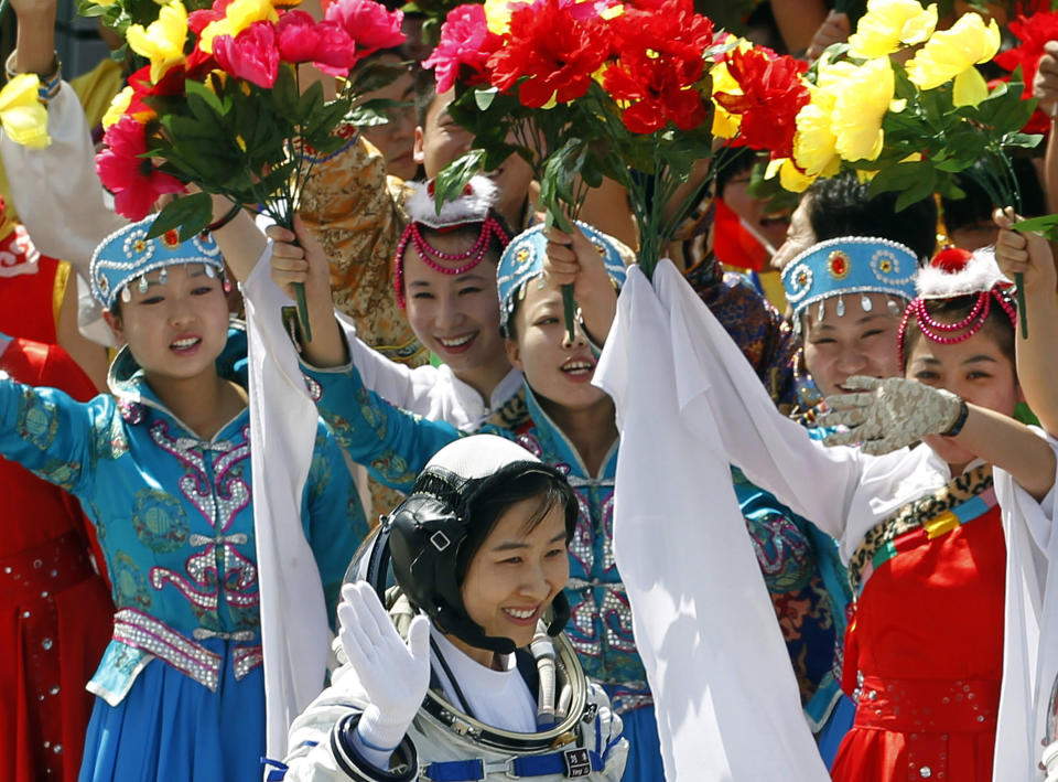 FILE - In this file photo taken Saturday, June 16, 2012, China's first female astronaut Liu Yang, bottom, waves during a sending off ceremony as she departs for the Shenzhou 9 spacecraft rocket launch pad at the Jiuquan Satellite Launch Center in Jiuquan, China. A glance at history suggests it's easier for a Chinese woman to orbit Earth than to land a spot on the highest rung of Chinese politics. In June, the 33-year-old Air Force major marked a major feminist milestone by becoming the first Chinese woman to travel in space. With a once-a-decade leadership transition set to kick off Nov. 8, many now are waiting to see if another ambitious Chinese female, State Councilor Liu Yandong, can win one of the nine spots at the apex of Chinese power.(AP Photo/Ng Han Guan, File)