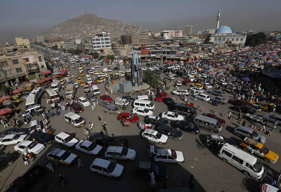 Vehicles drive at a junction in downtown Kabul