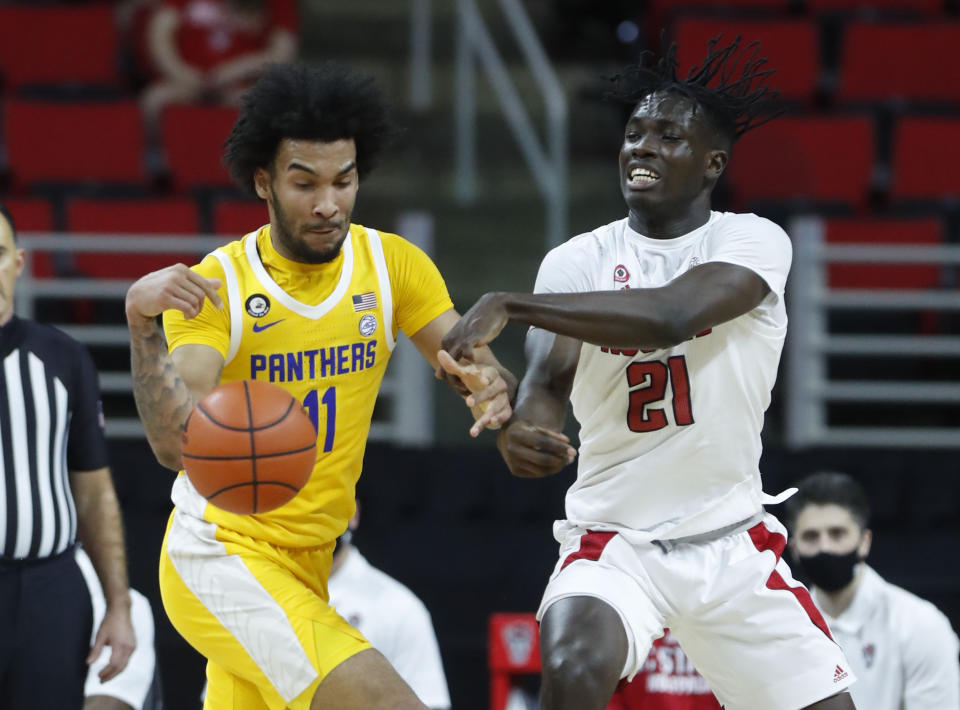 Pittsburgh's Justin Champagnie (11) and N.C. State's Ebenezer Dowuona (21) go after the ball during the first half of an NCAA college basketball game in Raleigh, N.C., Sunday, Feb. 28, 2021. (Ethan Hyman/The News & Observer via AP)