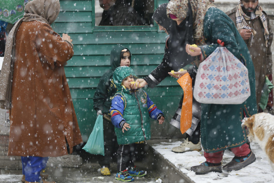 <p>A Kashmiri woman feeds her child during a fresh snow fall in Srinagar, Wednesday, Jan. 16, 2019. Snowfall has disrupted air traffic, and road traffic between Srinagar and Jammu. (AP Photo/Mukhtar Khan) </p>