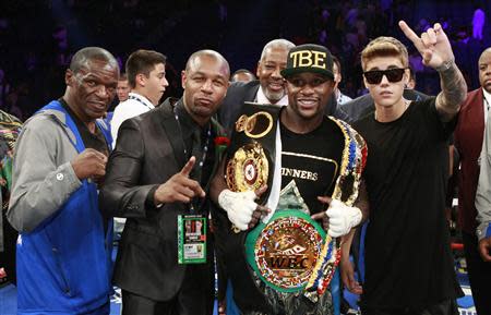 Floyd Mayweather Sr. (L), R&B singer Tank (2nd L), and singer Justin Bieber (R) celebrate Floyd Mayweather Jr.'s victory over WBC/WBA 154-pound champion Canelo Alvarez (not pictured) at the MGM Grand Garden Arena in Las Vegas, Nevada, September 14, 2013. Alvarez was previously undefeated in 42 fights. REUTERS/Steve Marcus