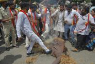 Activists belonging to various farmers rights organisations burn the effigy of Karnataka Chief Minister B. S. Yediyurappa during an anti-government demonstration to protest against the recent passing of new farm bills in parliament, in Bangalore on September 28, 2020. (Photo by Manjunath Kiran / AFP) (Photo by MANJUNATH KIRAN/AFP via Getty Images)