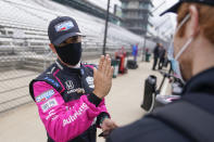 Helio Castroneves, of Brazil, talks with a crew member during testing at the Indianapolis Motor Speedway, Thursday, April 8, 2021, in Indianapolis. (AP Photo/Darron Cummings)