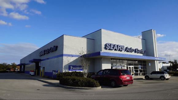 Sears auto center location with a couple of cars parked outside.