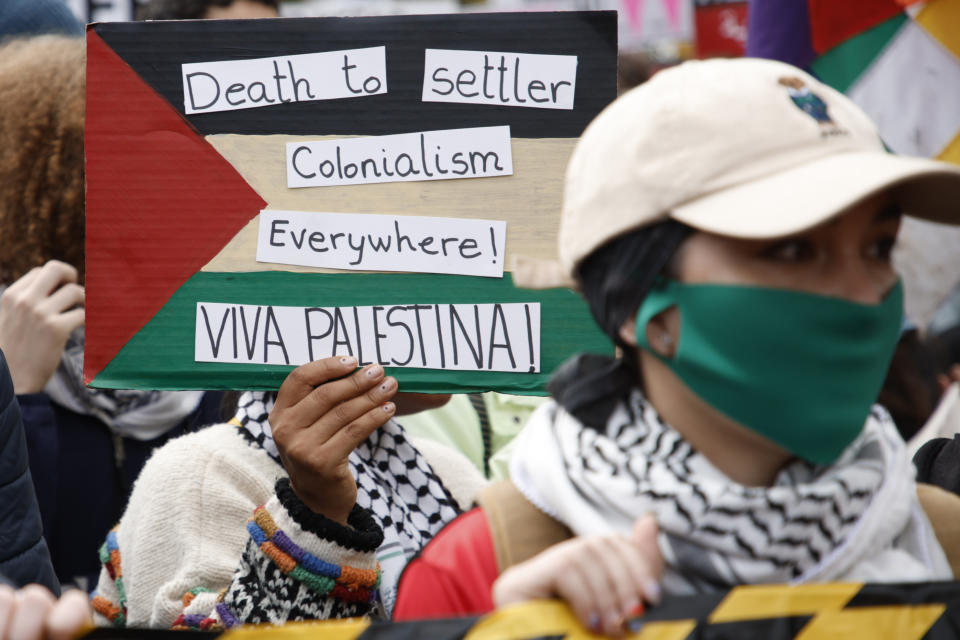 Demonstrators hold up flags and placards during a pro Palestinian demonstration in London, Saturday, Oct. 21, 2023. (AP Photo/David Cliff)