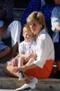 <p>Harry sits on Princess Diana's lap on the steps Marivent Palace during a family vacation.</p>