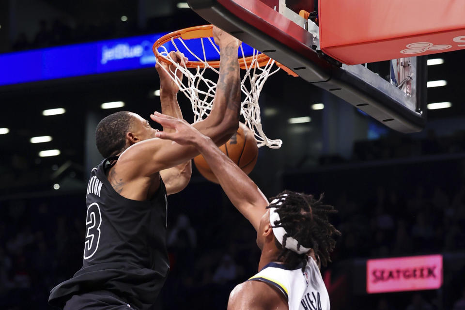 Brooklyn Nets forward Nic Claxton, left, dunks against Indiana Pacers guard Buddy Hield, right, during the second half of an NBA basketball game Monday, Oct. 31, 2022, in New York. (AP Photo/Jessie Alcheh)