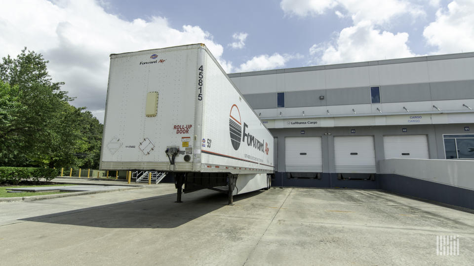 A white Forward Air trailer backed up to a Lufthansa terminal door