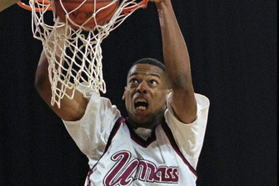 FILE - University of Massachusetts' center Marcus Camby (21) dunks against Georgetown during an NCAA college basketball tournament game at the Georgia Done in Atlanta, March 23, 1996. Massachusetts defeated Georgetown 86-62 to advance to the Final Four in New Jersey.(AP Photo/Andrew Innerarity, File)