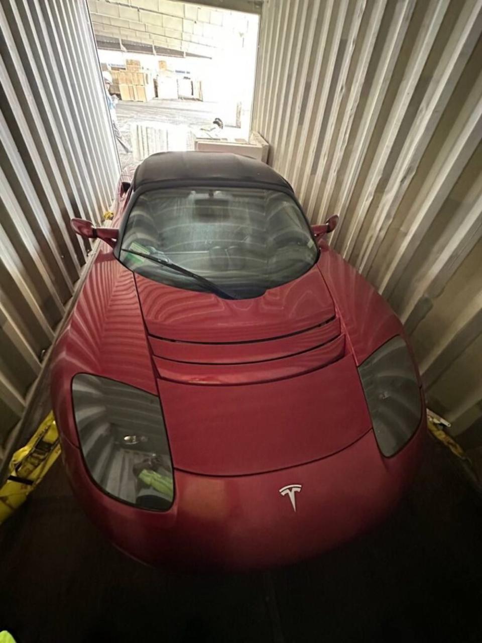 A view of a red 2010 Tesla Roadster that has gone untouched for over a decade. 