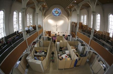Beds for migrants, separated by impromptu partition screens, are set up inside a Protestant church in Oberhausen, Germany, October 30, 2015. REUTERS/Ina Fassbender