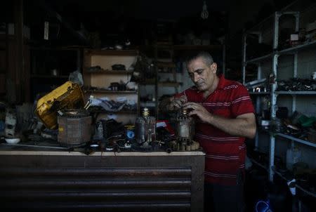 A Palestinian man works at his workshop as he fixes mobile power generators in Gaza City, July 9, 2017. REUTERS/Mohammed Salem