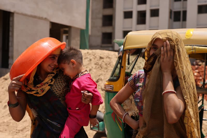FILE PHOTO: Women take shelter from the sun at a construction site in Ahmedabad