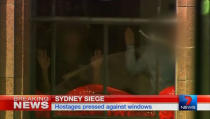 Hands are pressed up against the window of the Lindt cafe, where hostages are being held, in this still image taken from video from Australia's Seven Network on December 15, 2014. REUTERS/Reuters TV via Seven Network/Courtesy Seven Network