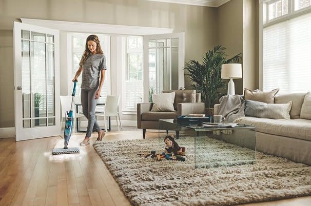 Woman mopping wooden floor of home