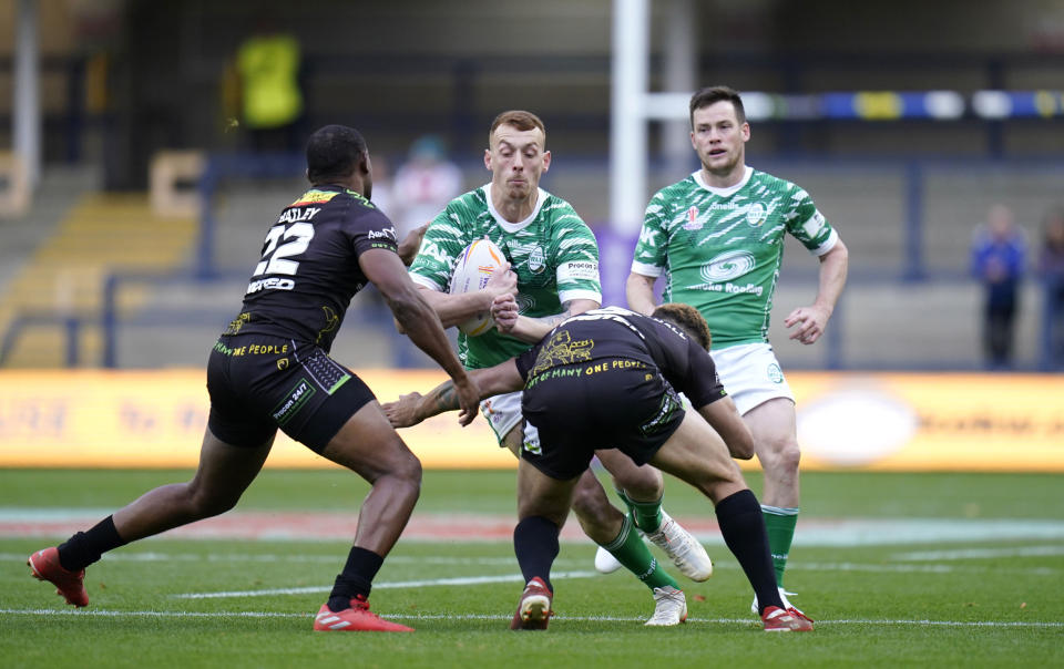 Ireland's Frankie Halton is tackled by Jamaica's James Woodburn-Hall, right, and Chevaughn Bailey during the Rugby League World Cup group C match between Ireland and Jamaica at Headingley Stadium, Leeds, England, Sunday Oct. 16, 2022. (Danny Lawson/PA via AP)