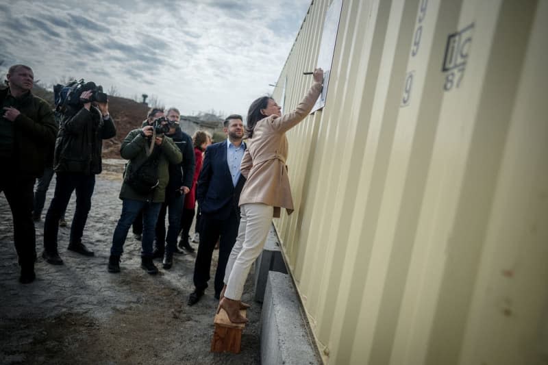 German Foreign Minister Annalena Baerbock signs a poster during a visit to a project for a water desalination plant near Mykolaiv. Kay Nietfeld/dpa