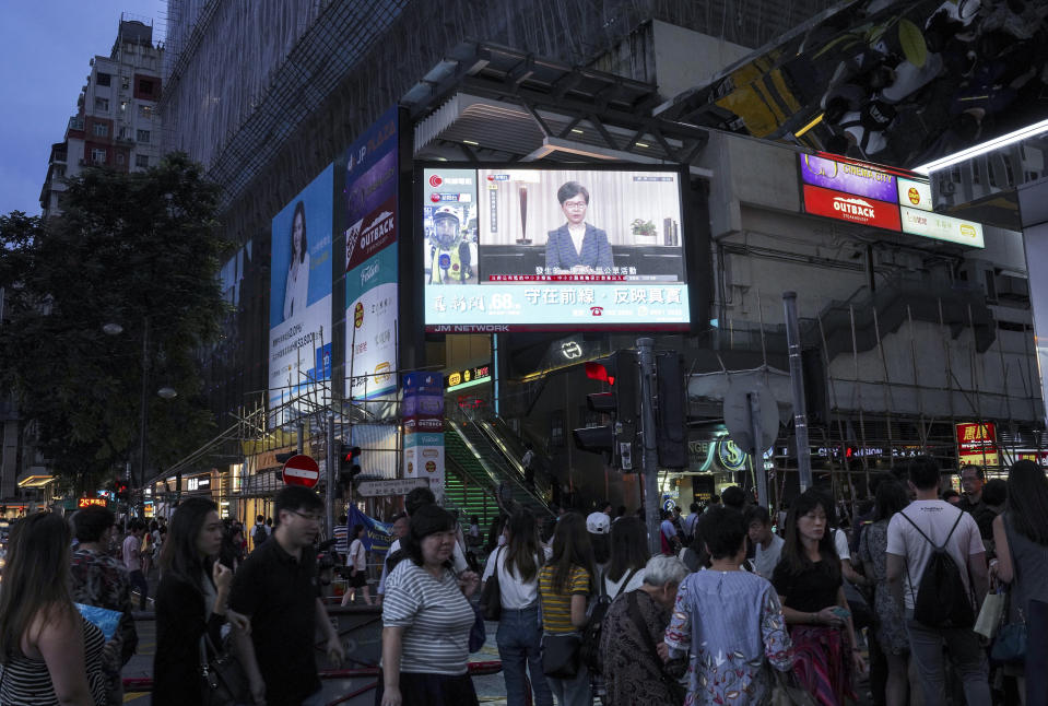 People watch telecast that Hong Kong Chief Executive Carrie Lam makes an announcement on an extradition bill, in Hong Kong, on Wednesday, Sept. 4, 2019. Chief Executive Lam has announced the government will formally withdraw an extradition bill that has sparked months of demonstrations in the city, bowing to one of the protesters' demands. The bill would have allowed Hong Kong residents to be sent to mainland China for trials. It sparked massive protests that have become increasingly violent and caused the airport to shut down earlier this month.(AP Photo/Vincent Yu)