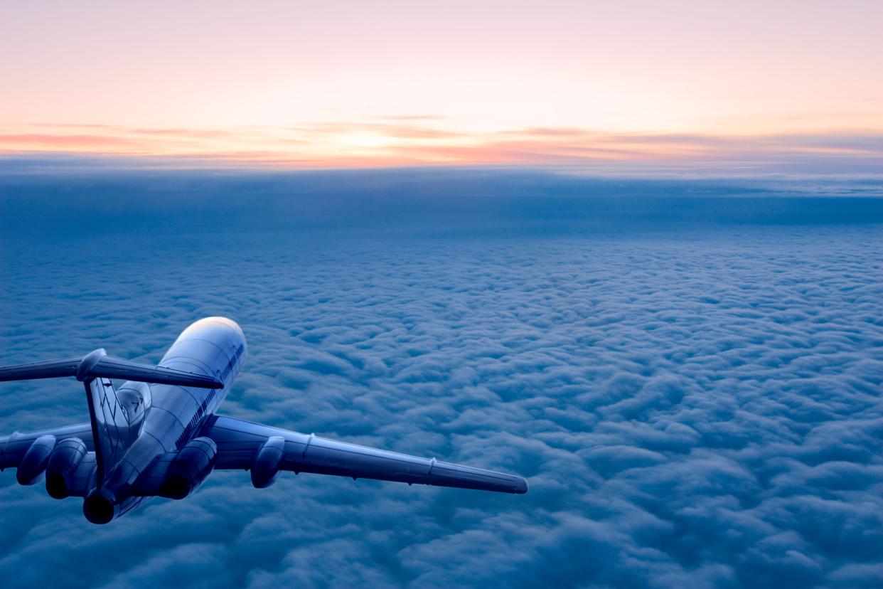 Passenger airplane on the clouds background. Flight in stratosphere. Daybreak.