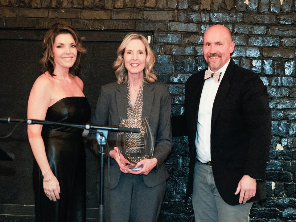 Carol Frederick accepts the Iris Award by the Associated General Contractors of Tennessee. Frederick received recognition at the Build Knoxville Awards on Jan. 25, celebrating her exemplary career and contributions to the construction industry, particularly in championing the role of women. From left: Erin Wakefield, Frederick and Drew Polahar.