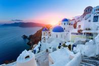 <p>Blue domed churches in a picturesque village at sunset in Santorini, Greece.</p>