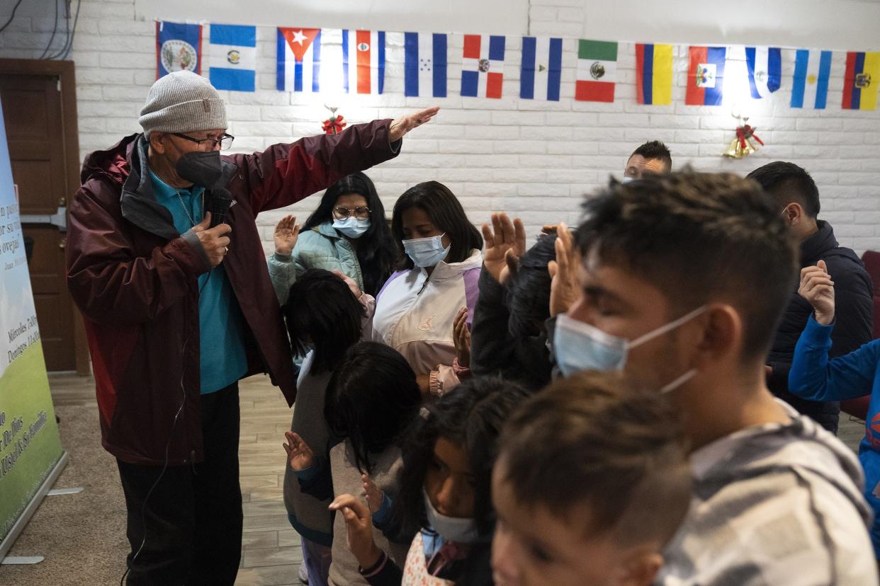 Pastor Hector Ramirez leads a prayer to protect a group of migrants on their journeys after they arrived to Iglesia Cristiana El Buen Pastor on Thursday, Dec. 22, 2022, in Mesa. The church was burglarized on Jan. 23, 2023.