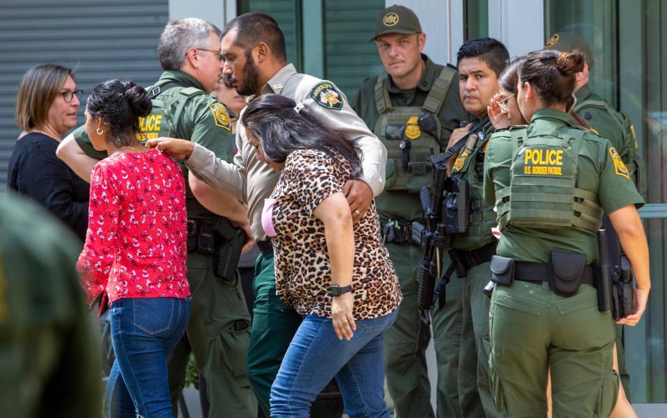 Law enforcement officers help relatives at the Uvalde Civic Center - AP