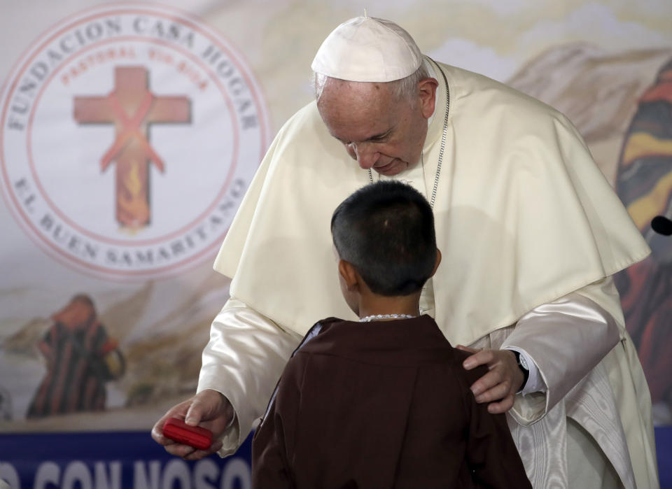 Pope Francis presents a gift to a child during his visit to the Casa Hogar del Buen Samaritano in Panama City, Sunday, Jan. 27, 2019. Francis wraps up his trip to the Central American country on Sunday with a final World Youth Day Mass and a visit to a church-run home for people living with AIDS. (AP Photo/Alessandra Tarantino)