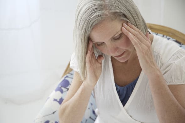 Mature woman pressing hands to sides of her head