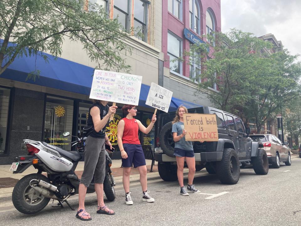 Three counter-protestor held signs, as around 40 people gathered at the Tippecanoe County Courthouse in Lafayette, Ind., June 26, 2022, to celebrate the U.S. Supreme Court overturning Roe v. Wade, the landmark decision that gave a woman the right to an abortion 50 years ago.