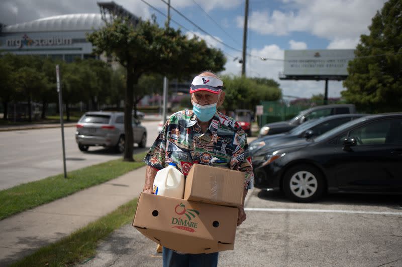 Man affected by economic fallout from the pandemic hold groceries provided by the Houston Food Bank in Texas