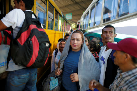 People in a caravan of migrants departing from El Salvador en route to the United States wait to board a bus, in San Salvador, El Salvador, November 18, 2018. REUTERS/Jose Cabezas