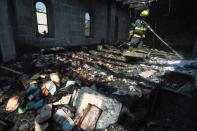 A fireman sprays water on debris at the Church of the Multiplication in Tabgha on June 18, 2015