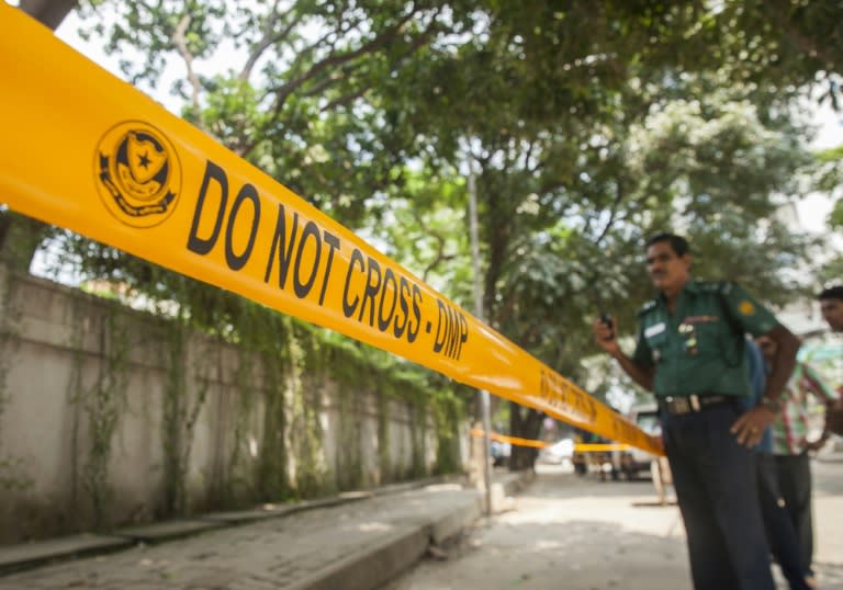 Bangladeshi police officers stand guard at the site where an Italian charity worker was shot to death by attackers, in Dhaka, on September 29, 2015