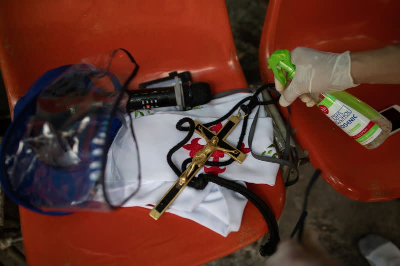 The Wider Image: Hazmat suits and holy water: two priests bring faith to Philippines lockdown