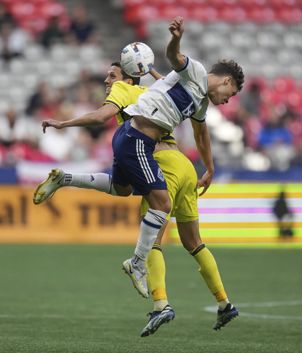 Vancouver Whitecaps' Sebastian Berhalter, right, and Nashville FC's Sean Davis, left, vie for the ball during first-half MLS soccer match action in Vancouver, British Columbia, Saturday, Aug. 27, 2022. (Darryl Dyck/The Canadian Press via AP)