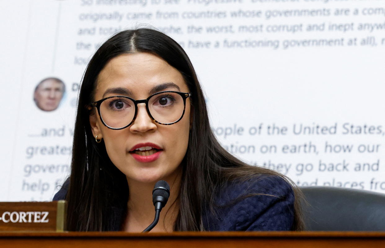 Rep. Alexandria Ocasio-Cortez at the microphone, looking earnest.