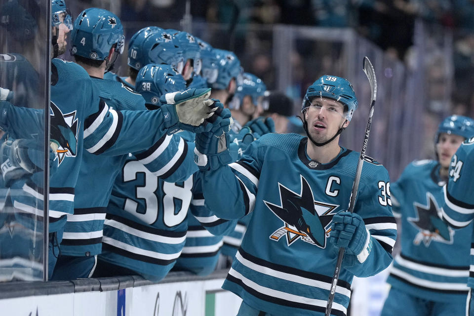 San Jose Sharks center Logan Couture (39) is congratulated by teammates after his goal against the Boston Bruins during the first period of an NHL hockey game Saturday, Jan. 7, 2023, in San Jose, Calif. (AP Photo/Tony Avelar)