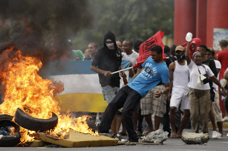 Demonstrators set on fire a barricade during a protest in downtown Colon, Panama, Tuesday, Oct. 23, 2012. Demonstrators protested over a new law allowing the sale of state-owned land in the duty-free zone next to the Panama Canal. Protesters said the land is already being rented and it makes no sense to sell it. They said the government should instead raise the rent and invest the money in Colon, a poor and violent city. (AP Photo/Arnulfo Franco)